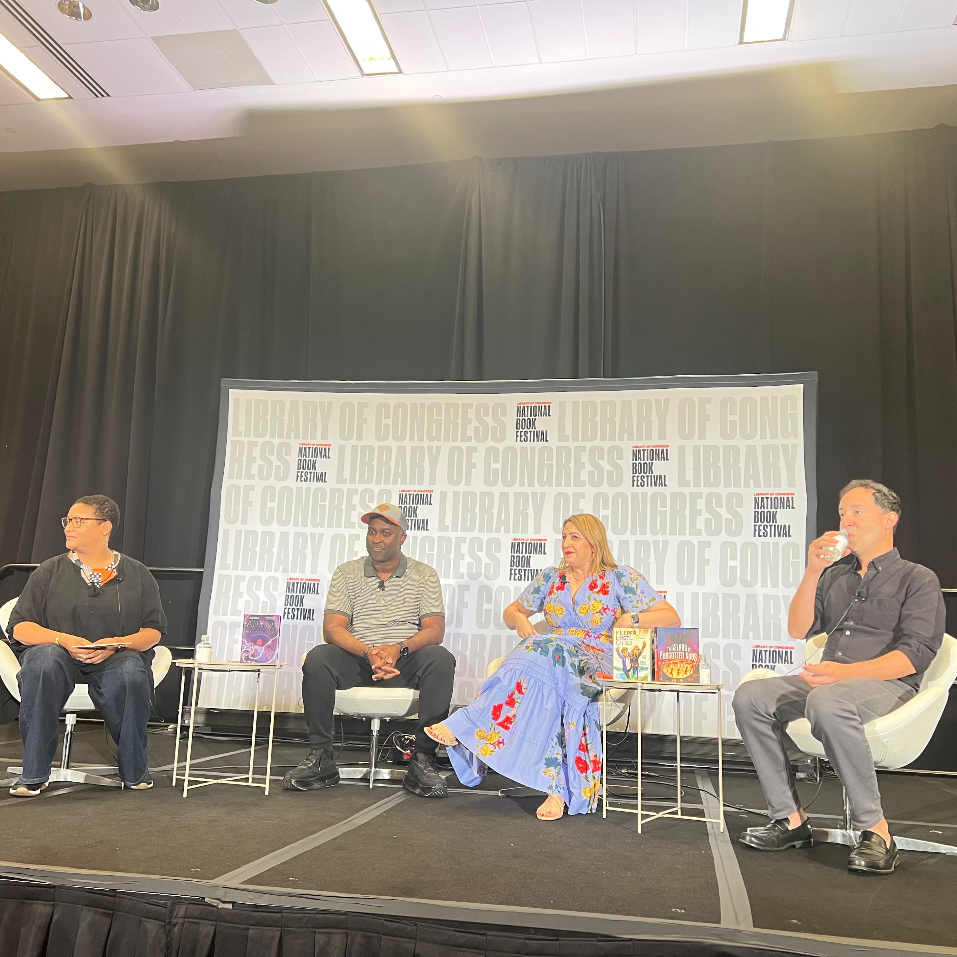 A panel of authors on stage in front of the Library of Congress National Book Festival backdrop