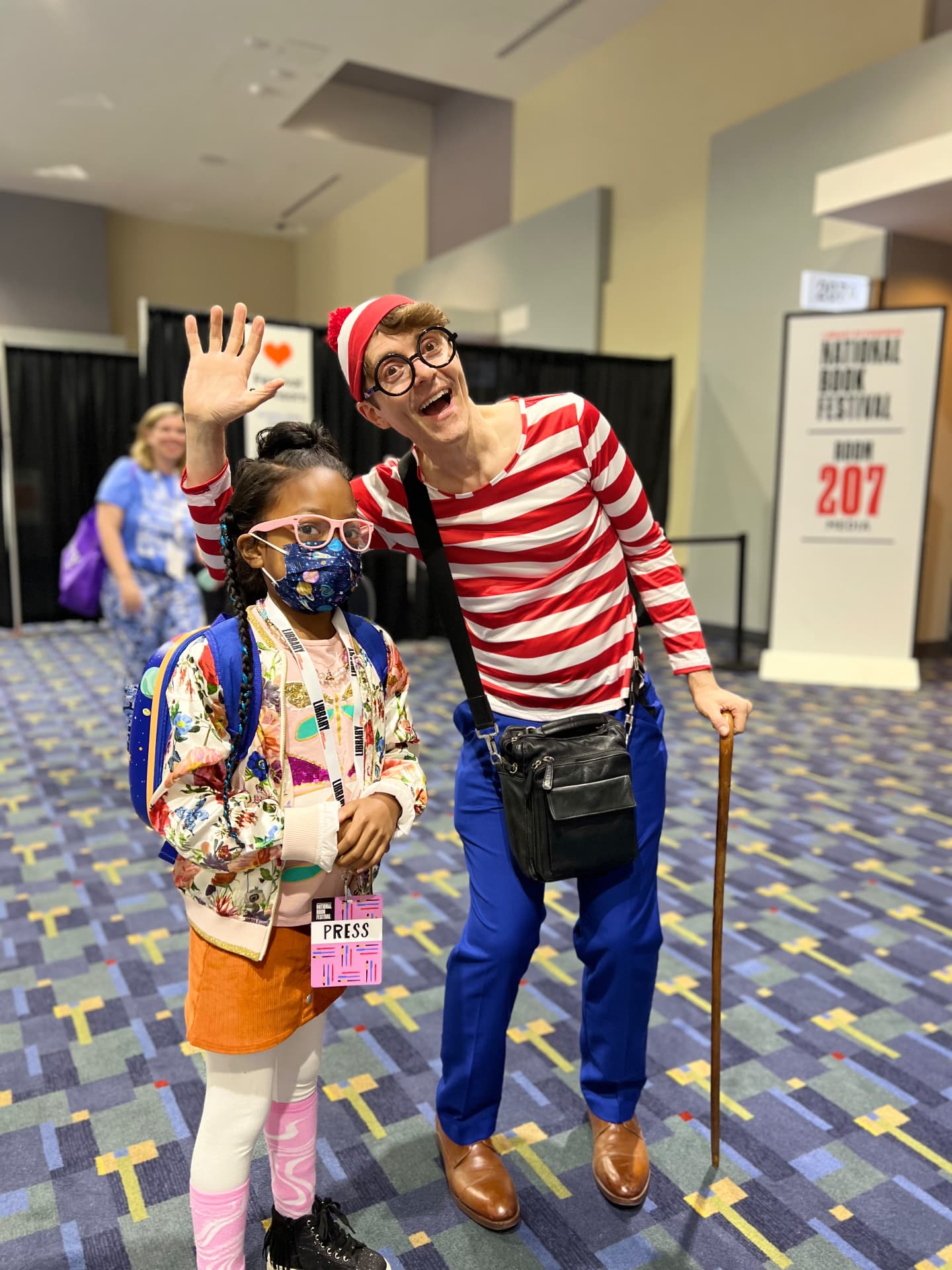 Ishara waving next to a performer dressed as Waldo