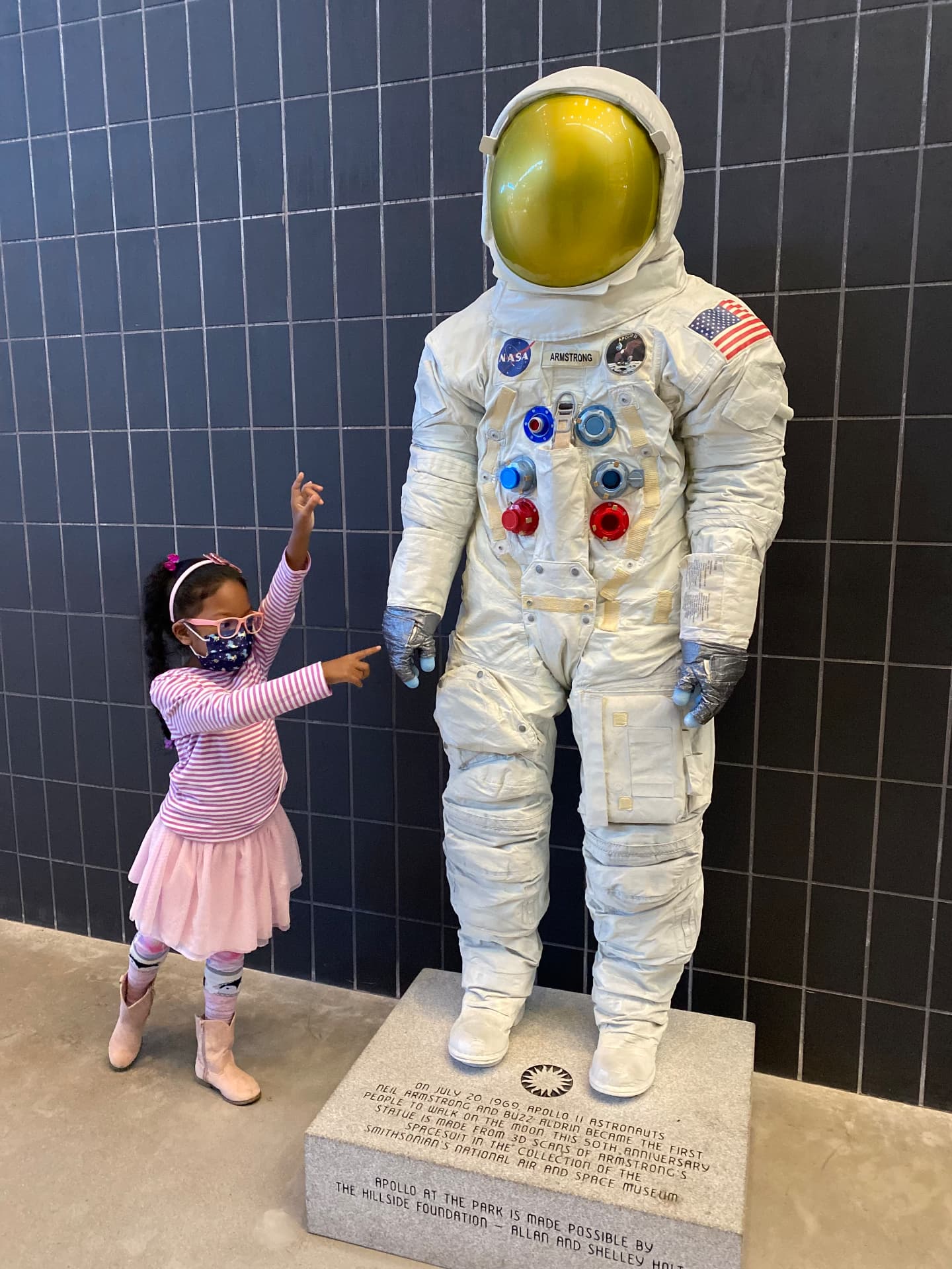 Ishara pointing at an Apollo astronaut spacesuit