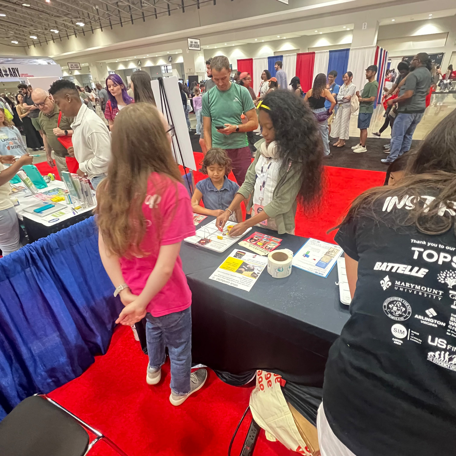 Ishara at a busy hands-on STEM booth in the festival exhibit hall