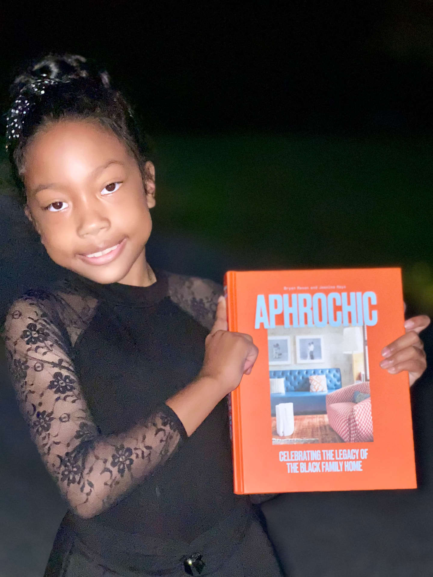 Ishara holding a copy of the AphroChic book