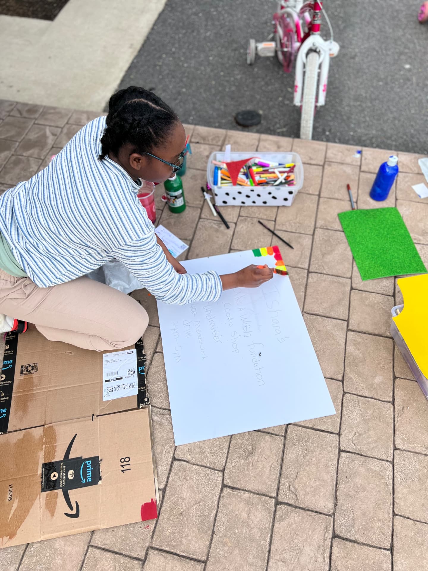 Ishara making a hand-lettered sign for her Make-A-Wish cookie shop fundraiser
