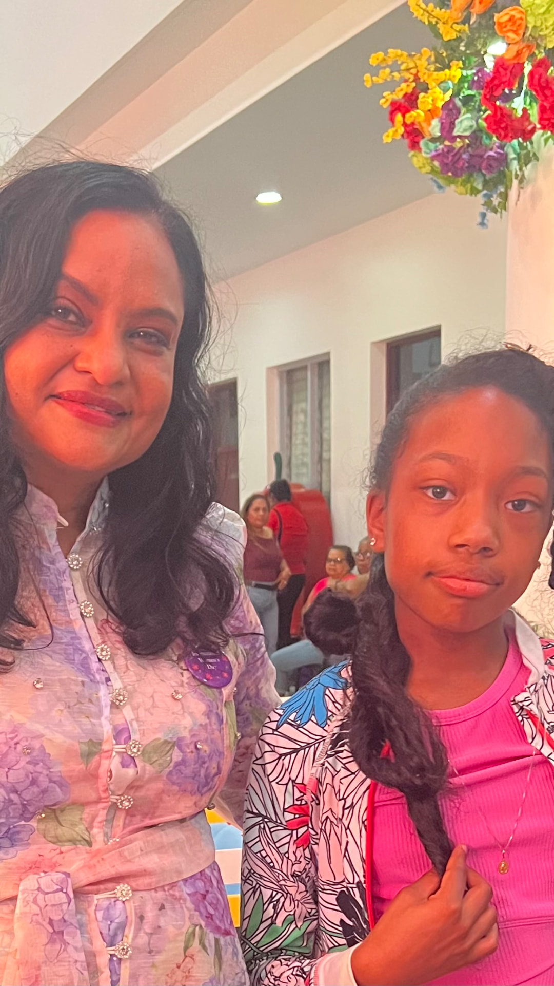 Ishara standing beside a woman at a reception in Guyana