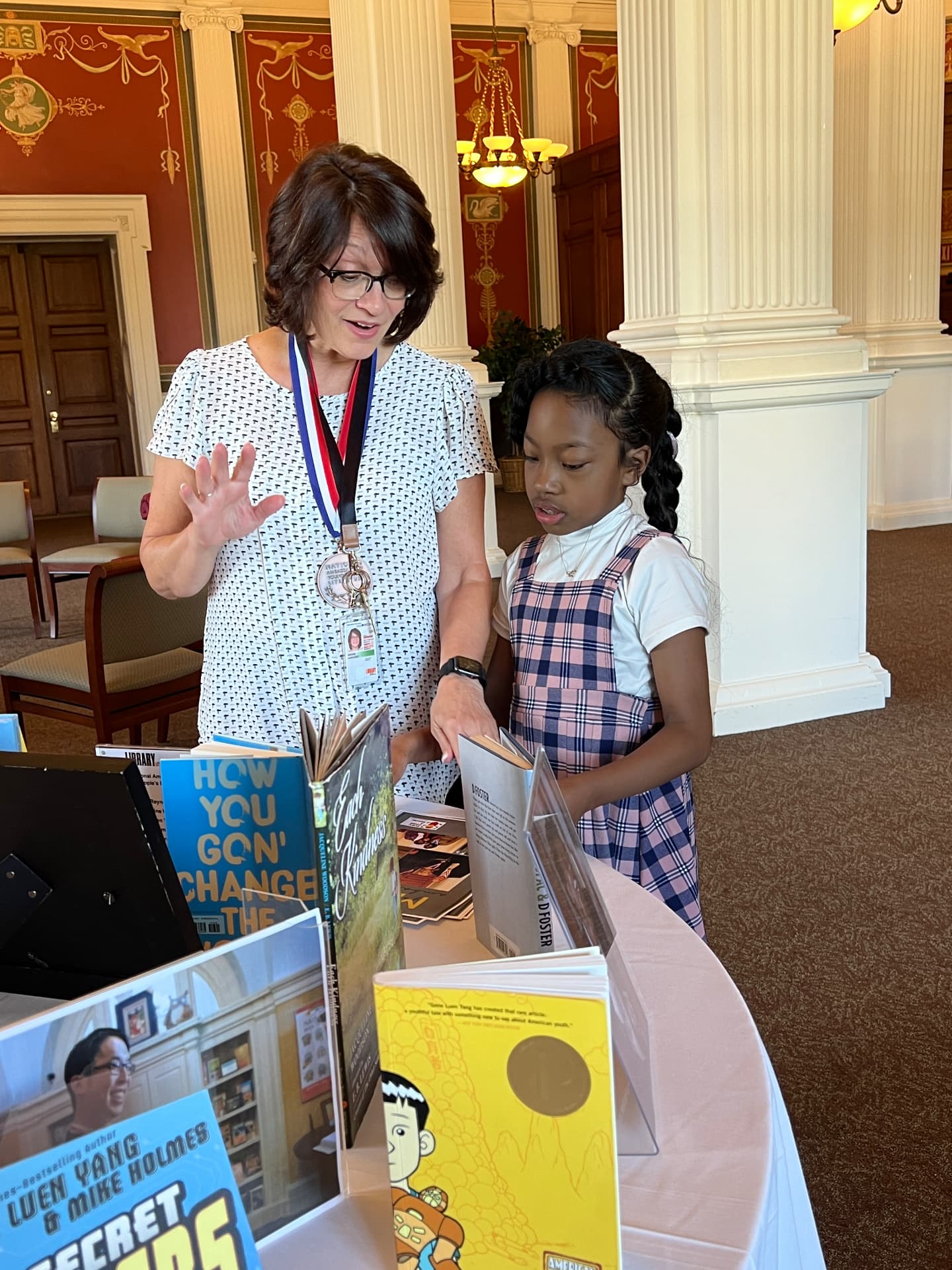 Meg Medina showing Ishara books displayed on a table at the Library of Congress