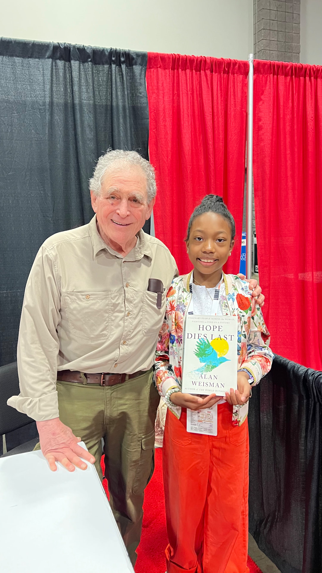 Ishara holding Hope Dies Last beside author Alan Weisman