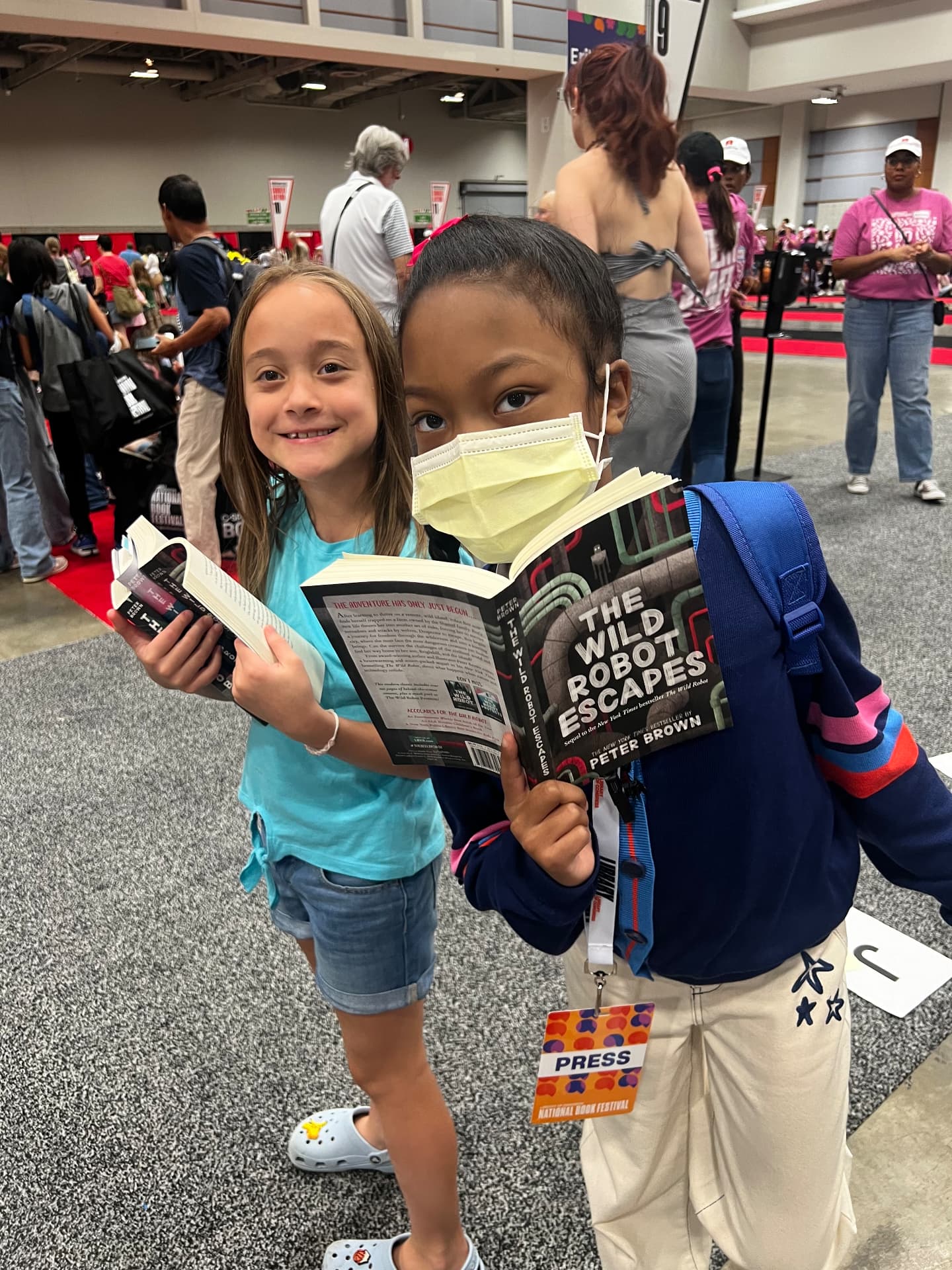 Ishara and another young reader reading The Wild Robot Escapes together