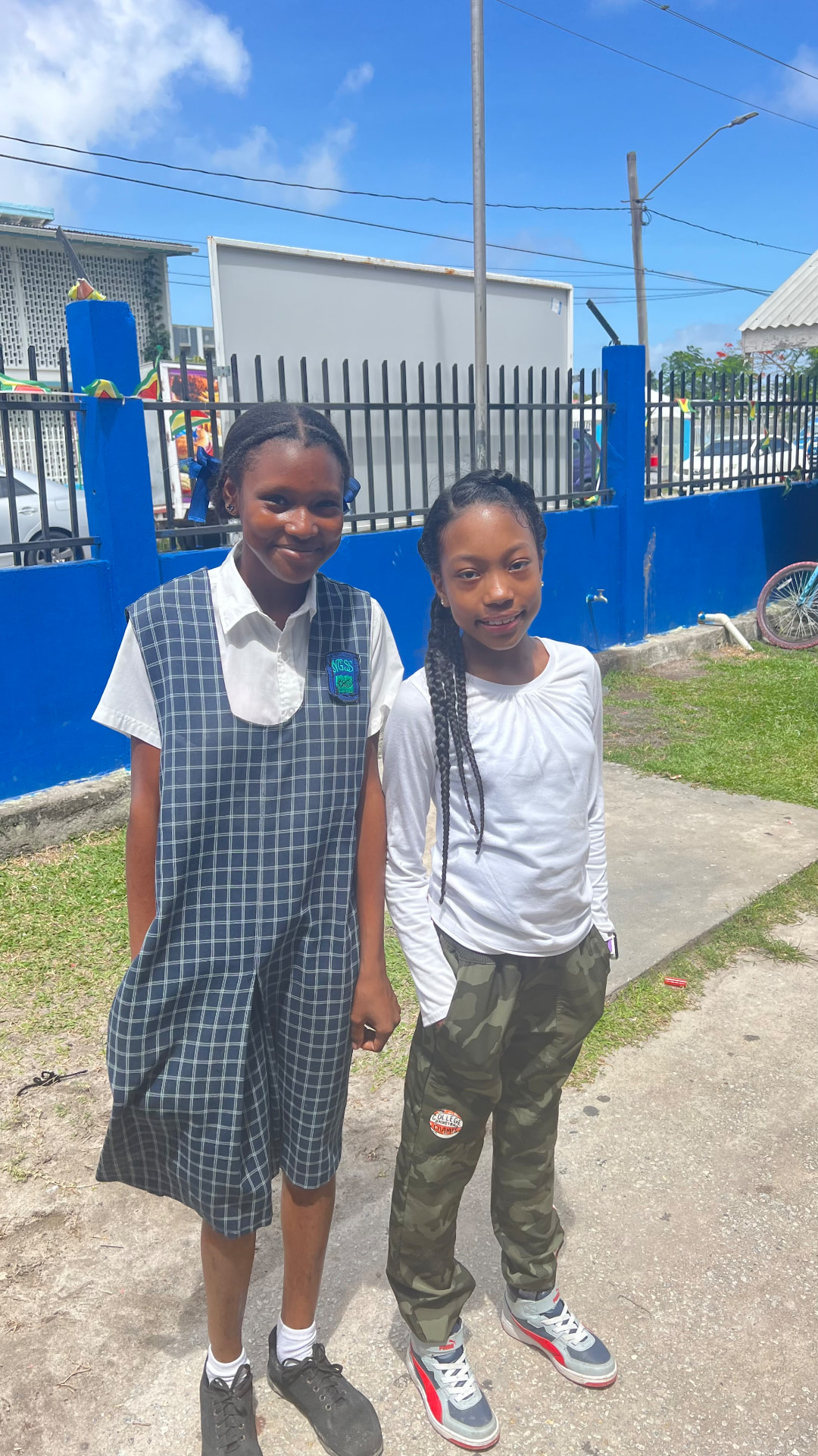 Ishara standing with a new friend outside school in Georgetown