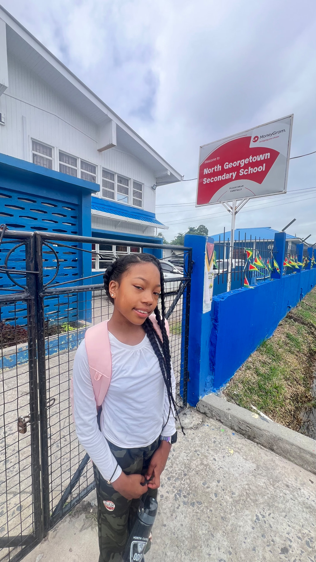 Ishara with her backpack outside North Georgetown Secondary School