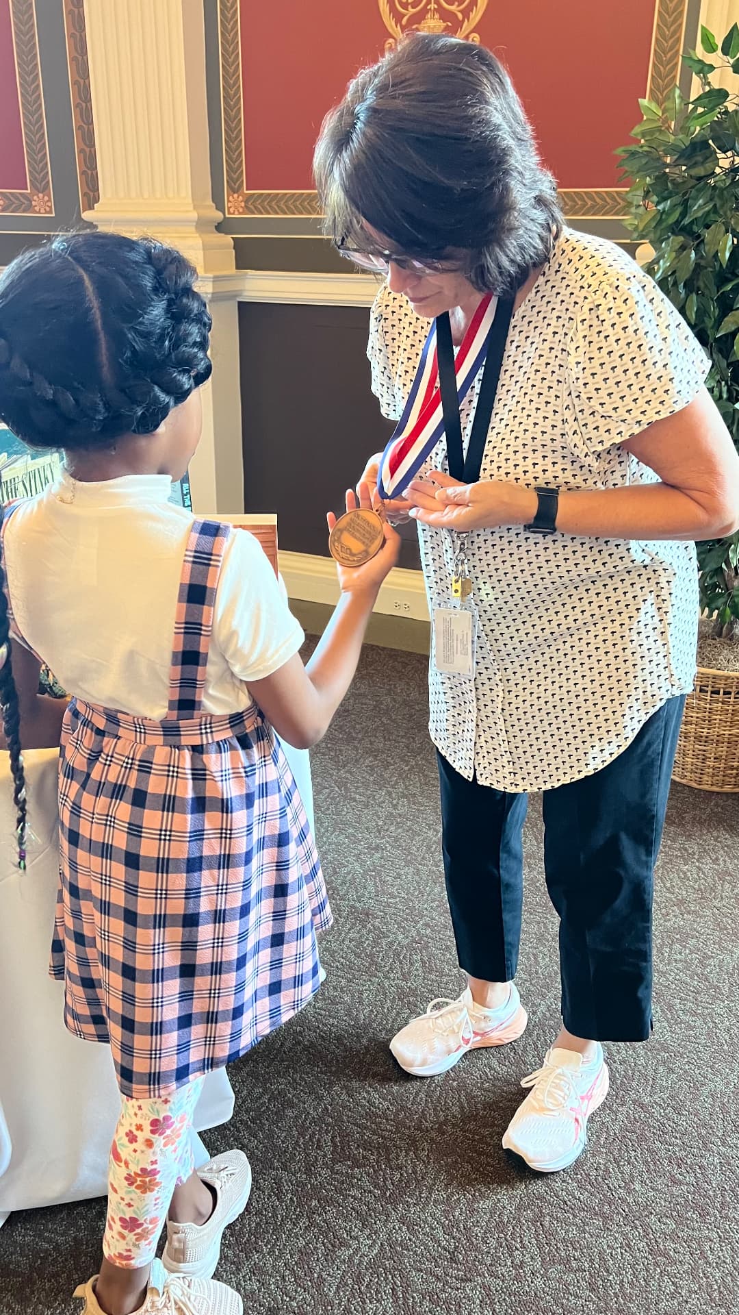 Ishara holding Meg Medina's National Ambassador for Young People's Literature medal