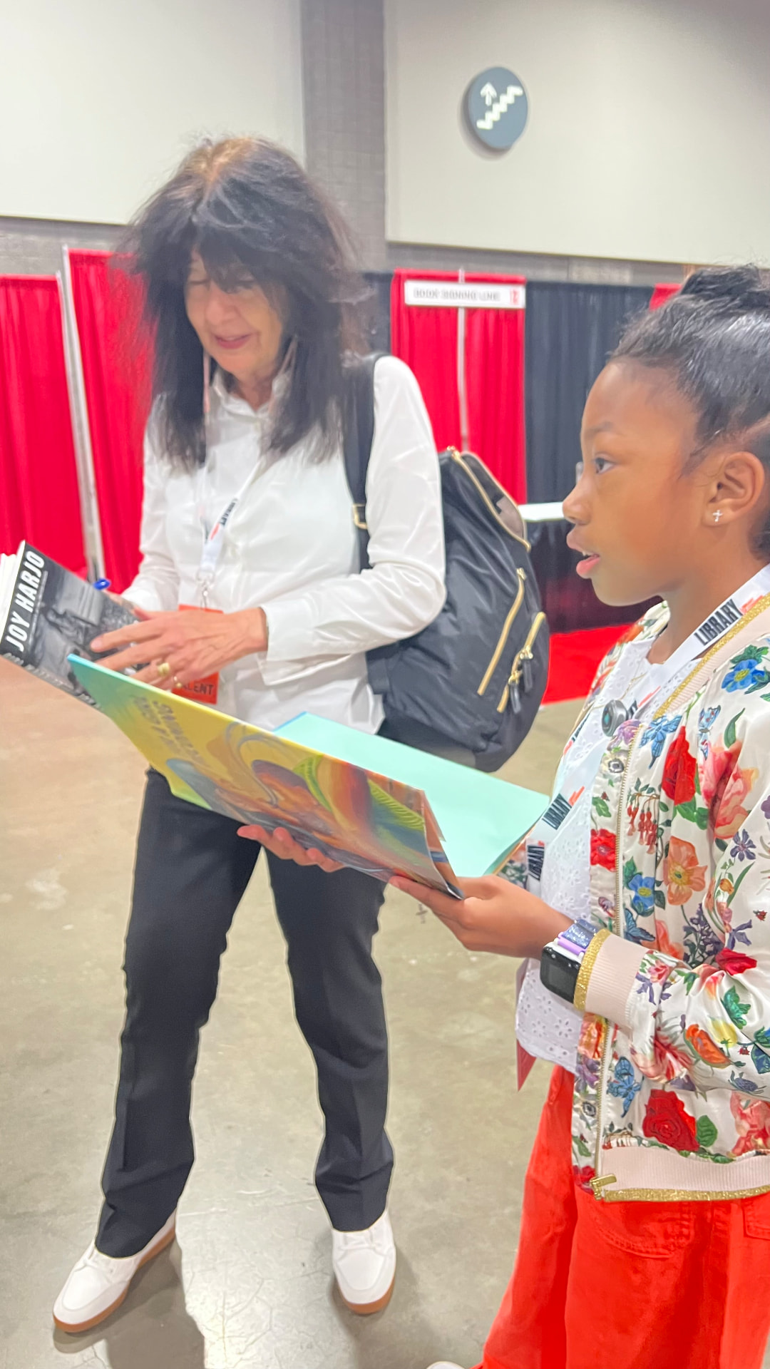 Ishara showing a picture book to U.S. Poet Laureate Joy Harjo