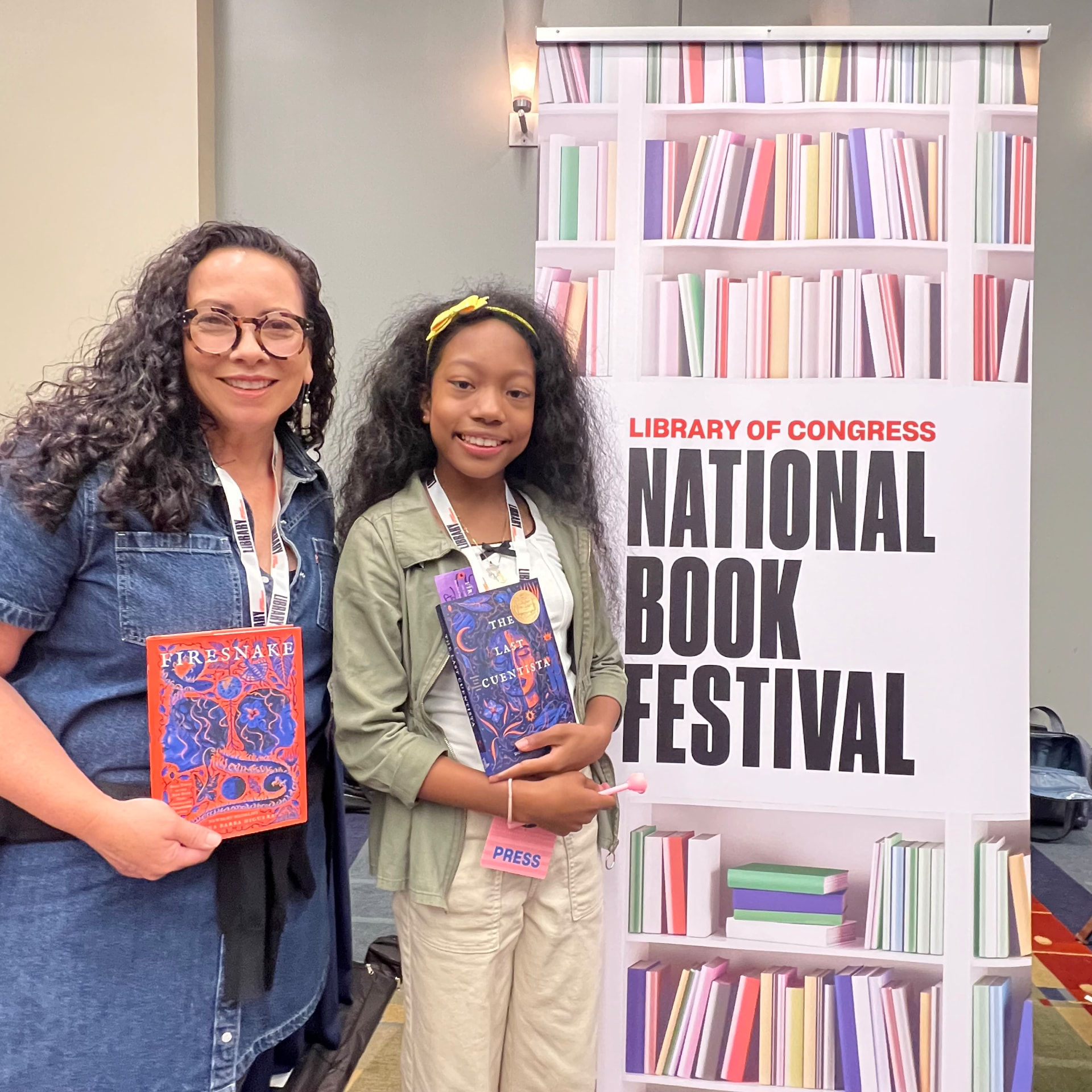 Ishara holding The Last Cuentista next to author Donna Barba Higuera holding Firesnake