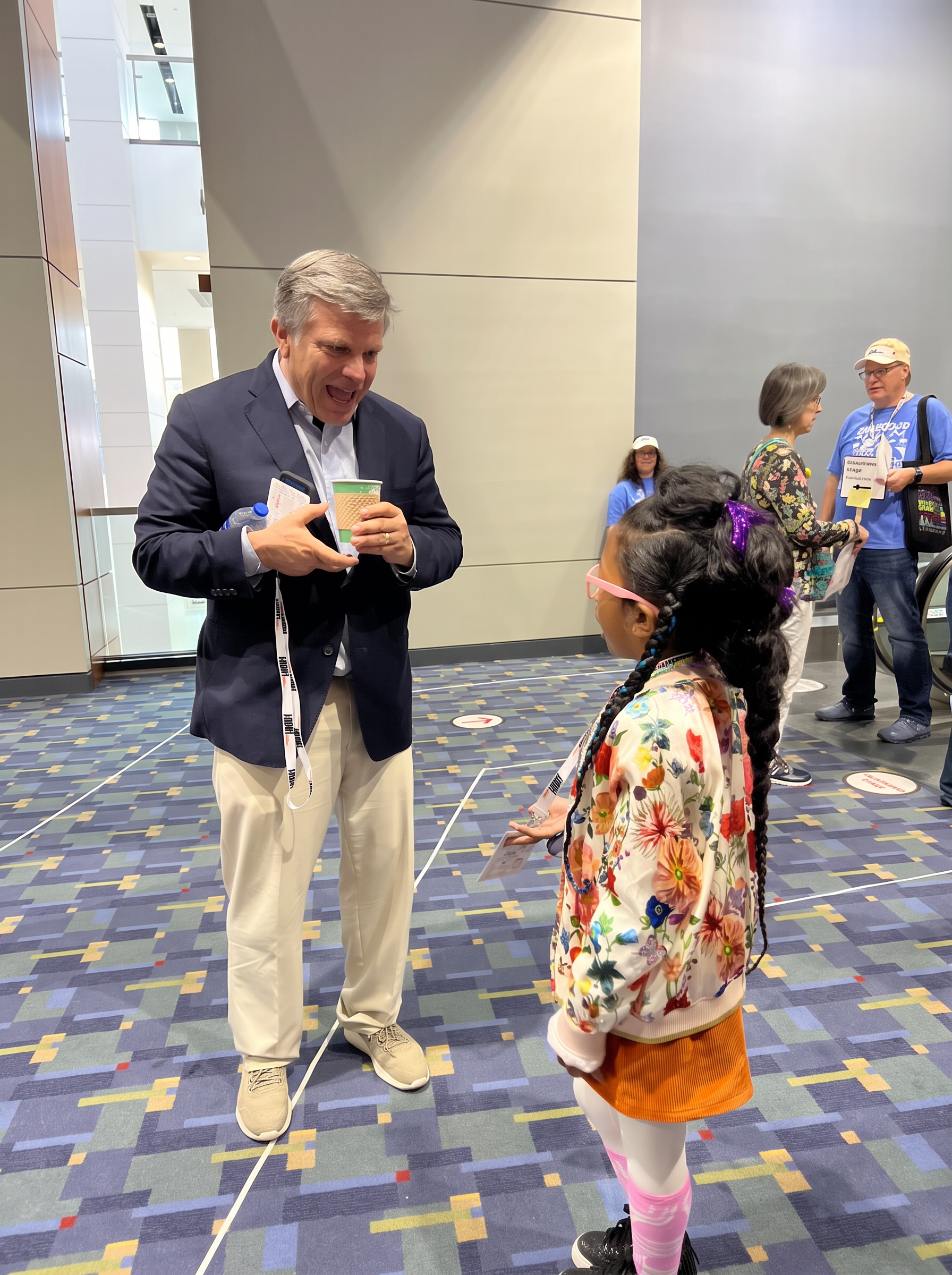 Ishara talking with a festival leader in the convention center lobby